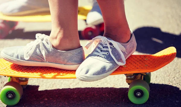 Primer plano de los pies a caballo patinetas en la calle de la ciudad — Foto de Stock