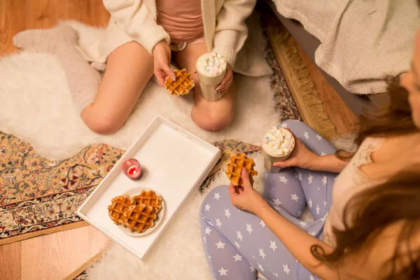 Mulheres bebendo chocolate quente e comendo waffles — Fotografia de Stock