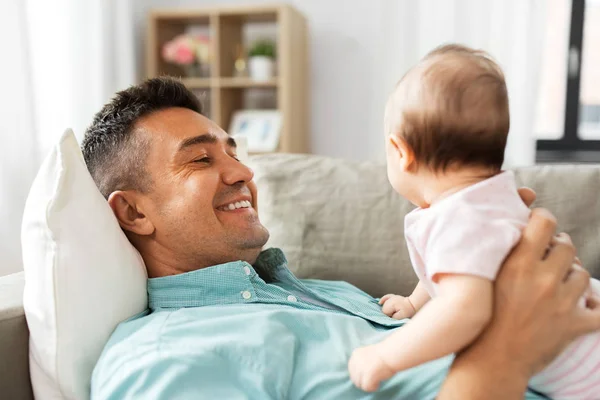 Padre de mediana edad con el bebé acostado en el sofá en casa — Foto de Stock