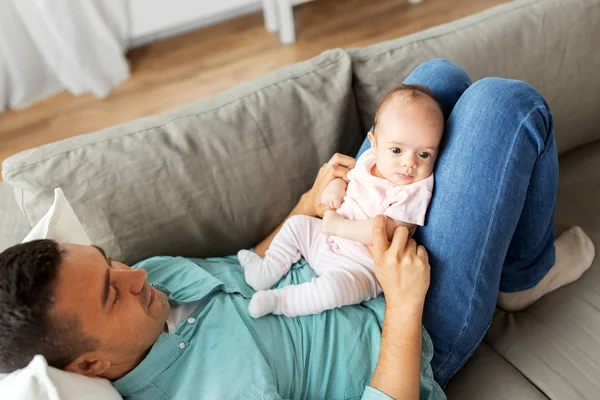 Middelbare leeftijd vader met baby liggend op de Bank thuis — Stockfoto