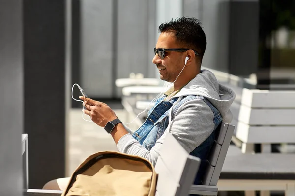 Man med hörlurar och smartphone på City Street — Stockfoto