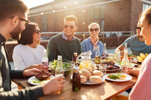 Přátelé mají večeři nebo bbq party na střeše — Stock fotografie