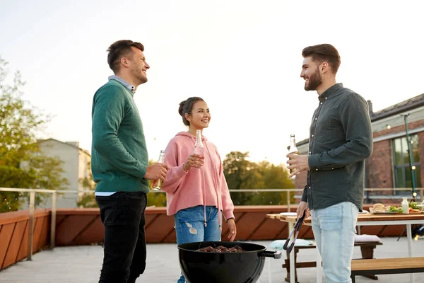 Amigos felices teniendo una fiesta de barbacoa en la azotea — Foto de Stock