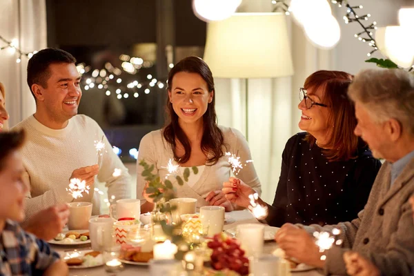 Family with sparklers having tea party at home — Stock Photo, Image