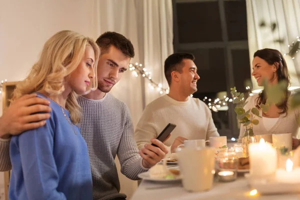 Glückliches Paar mit Smartphone bei Familien-Teeparty — Stockfoto