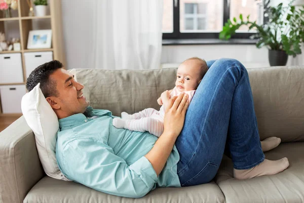 Padre de mediana edad con el bebé acostado en el sofá en casa — Foto de Stock