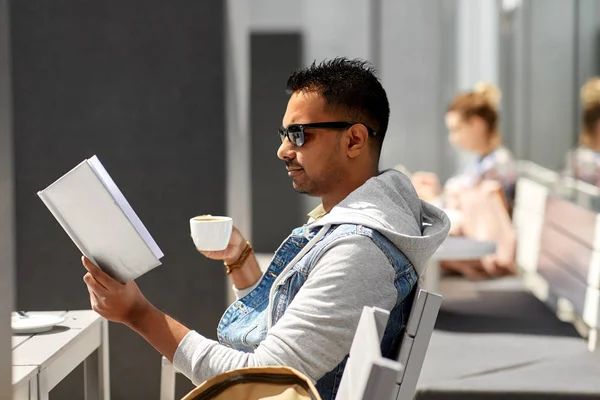 Hombre leyendo libro y beber café en el café de la ciudad —  Fotos de Stock