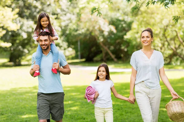 Família com cesta de piquenique andando no parque de verão — Fotografia de Stock