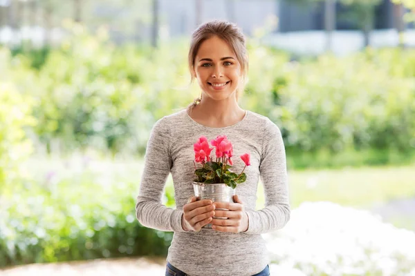 Giovane donna con fiori di ciclamino nel giardino estivo — Foto Stock