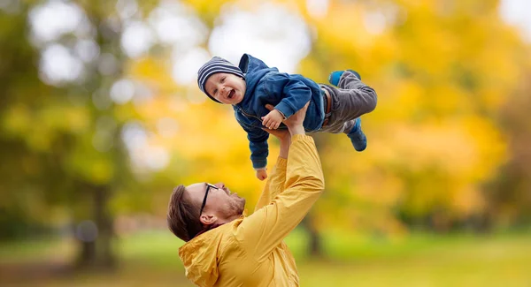 Padre con hijo jugando y divirtiéndose en otoño — Foto de Stock