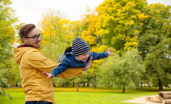 Padre con hijo jugando y divirtiéndose en otoño — Foto de Stock