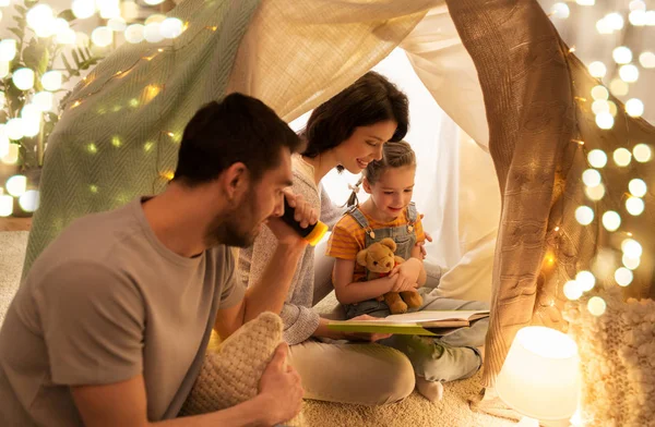 Lycklig familj läsebok i barn tält hemma — Stockfoto
