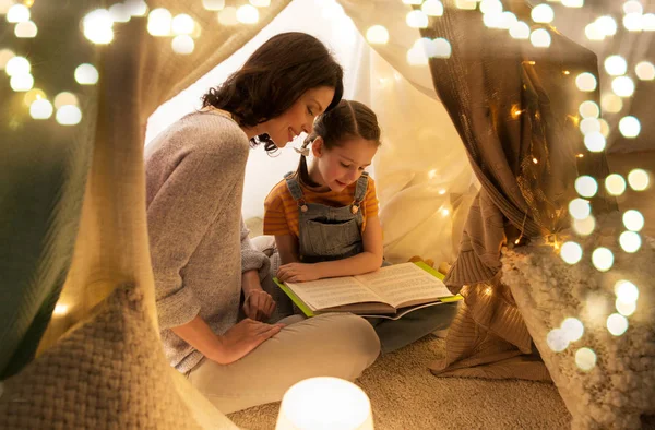 Lycklig familj läsebok i barn tält hemma — Stockfoto