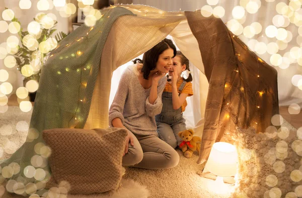 Famiglia felice sussurrando nella tenda dei bambini a casa — Foto Stock