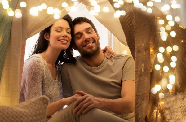 Happy couple in kids tent at home — Stock Photo, Image