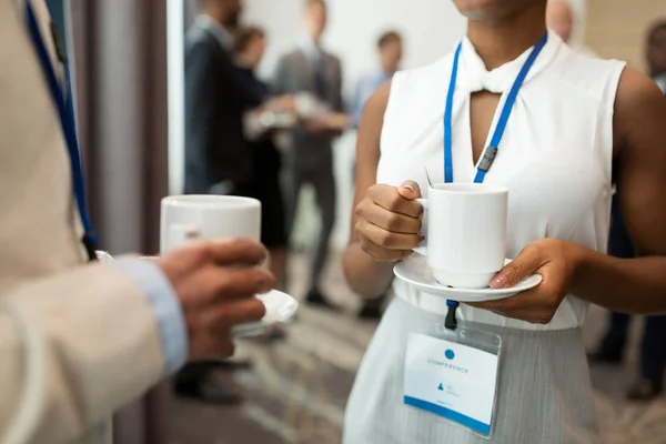 Affärsfolk med konferensen märken och kaffe — Stockfoto