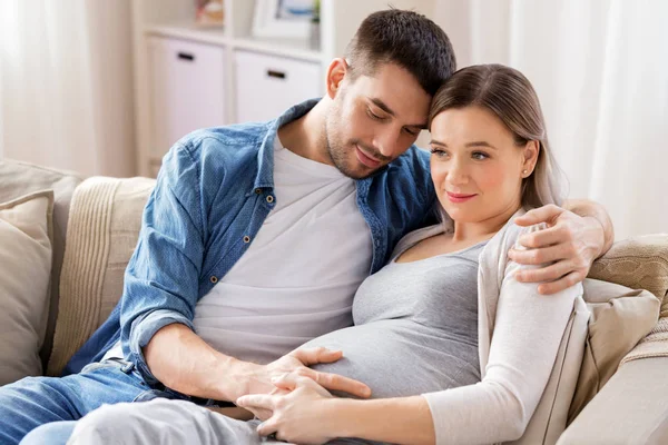 집에서 임신 한 여자를 껴안고 있는 남자 — 스톡 사진