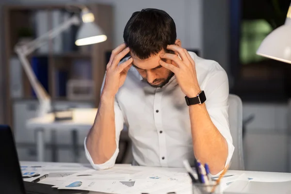 Homme d'affaires avec des papiers travaillant au bureau de nuit — Photo