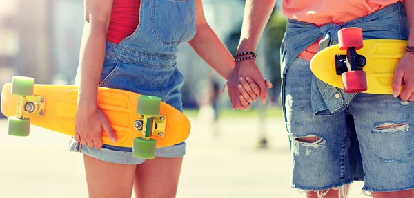 Close up de jovem casal com skates na cidade — Fotografia de Stock