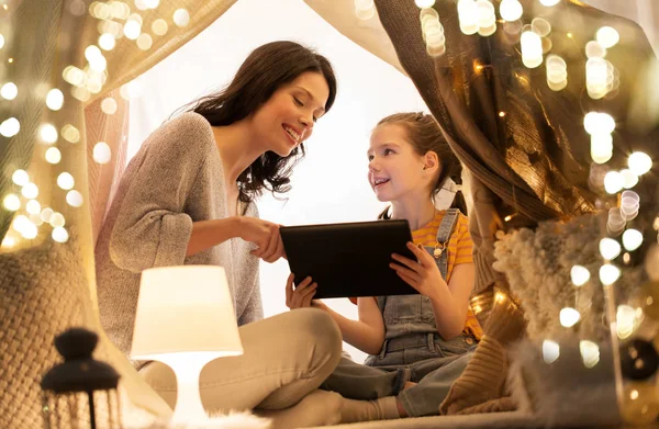 Familia con tablet pc en tienda de campaña para niños en casa — Foto de Stock