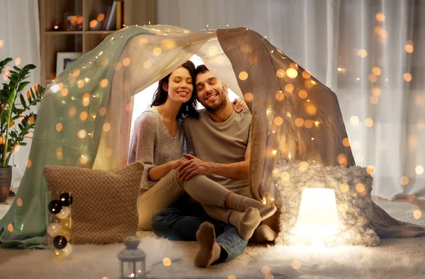 Счастливая пара в детской палатке дома — стоковое фото