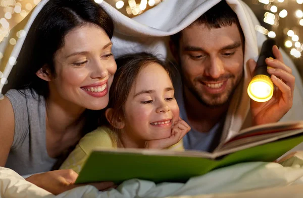 Libro de lectura familiar feliz en la cama por la noche en casa —  Fotos de Stock