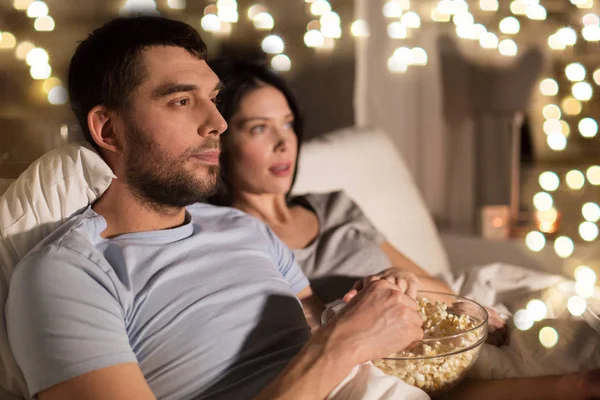 Casal com pipocas assistindo tv à noite em casa — Fotografia de Stock