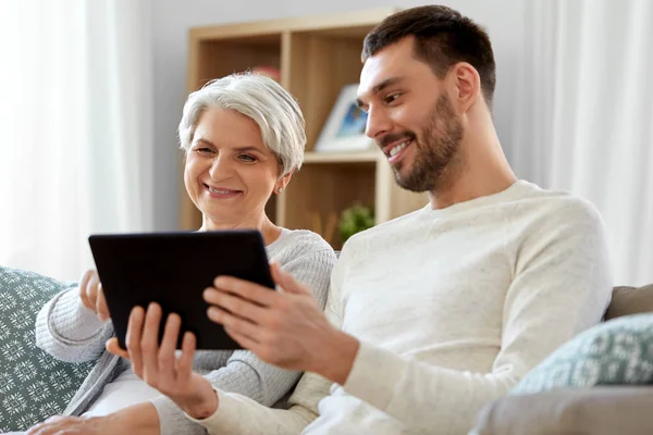 Alte Mutter und erwachsener Sohn mit Tablet-PC zu Hause — Stockfoto