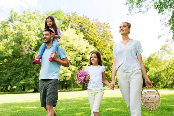 Keluarga dengan keranjang piknik berjalan di taman musim panas — Stok Foto
