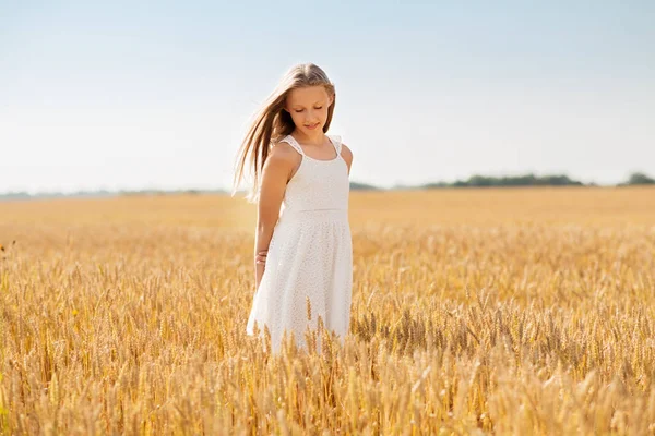 Glimlachend jong meisje op graanveld in de zomer — Stockfoto