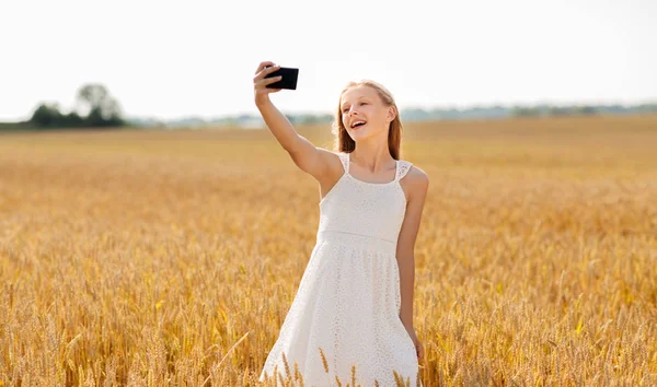 Happy young girl taking selfie by smartphone — Stock Photo, Image