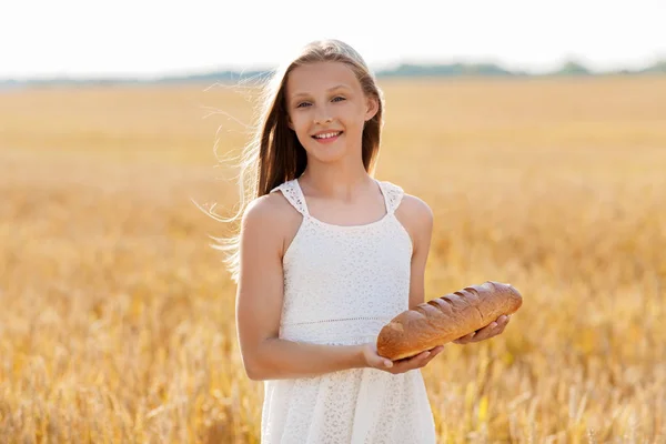 Menina com pão branco no campo de cereais — Fotografia de Stock