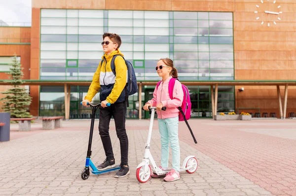 Schoolkinderen met rugzakken rijden steppen — Stockfoto