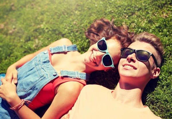 Gelukkig tiener paar liggend op gras in de zomer — Stockfoto