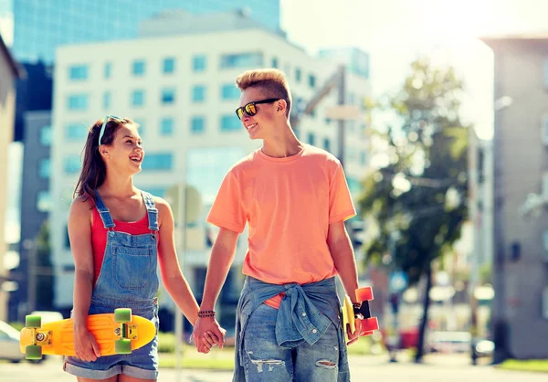 Teenage couple with skateboards on city street — Stock Photo, Image