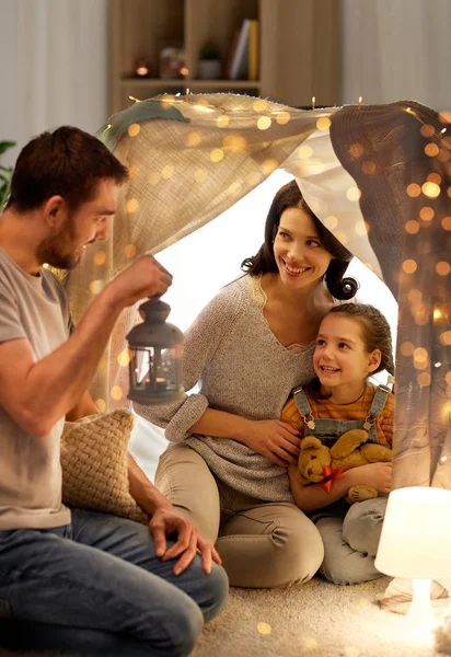 Famille heureuse jouant dans la tente des enfants la nuit à la maison — Photo