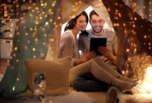 Casal feliz com tablet pc na tenda crianças em casa — Fotografia de Stock