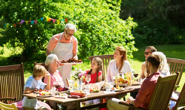 Familie beim Abendessen oder Grillen im Sommergarten — Stockfoto