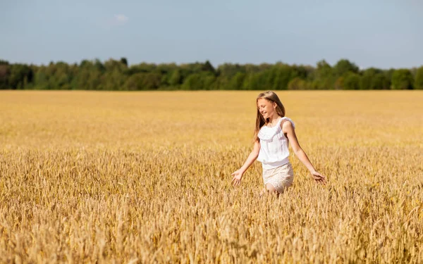 Souriant jeune fille sur le champ de céréales en été — Photo