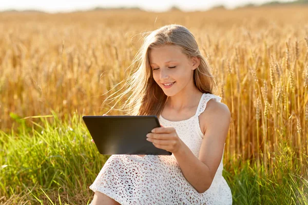 Sonriendo con la tableta en el campo de cereales — Foto de Stock