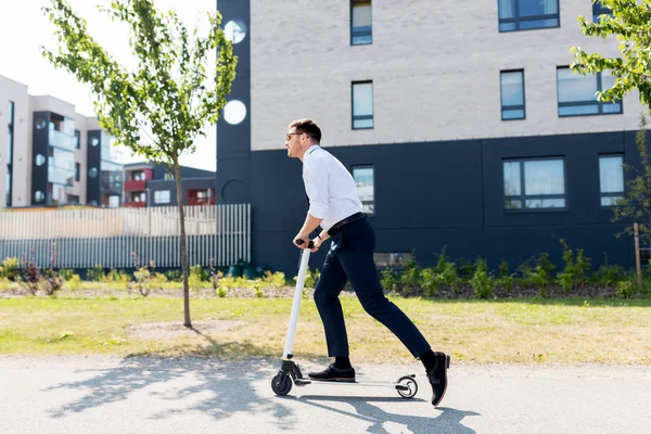 Jonge zakenman paardrijden elektrische scooter buiten — Stockfoto