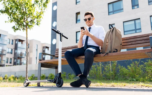 Geschäftsmann mit Smartphone, Rucksack und Roller — Stockfoto