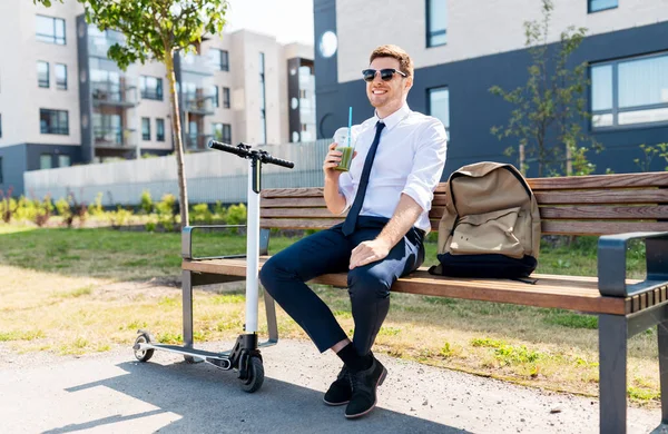 Бізнесмен з скутером п'є софі в місті — стокове фото