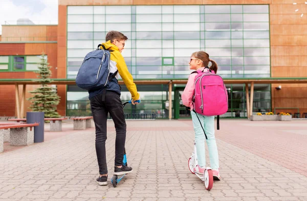 Schoolkinderen met rugzakken rijden steppen — Stockfoto