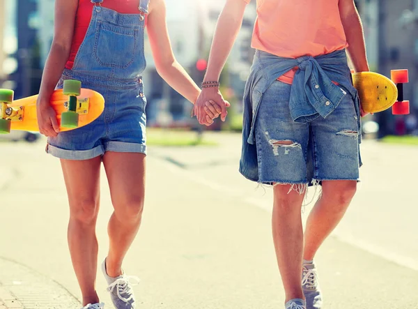 Close up de jovem casal com skates na cidade — Fotografia de Stock