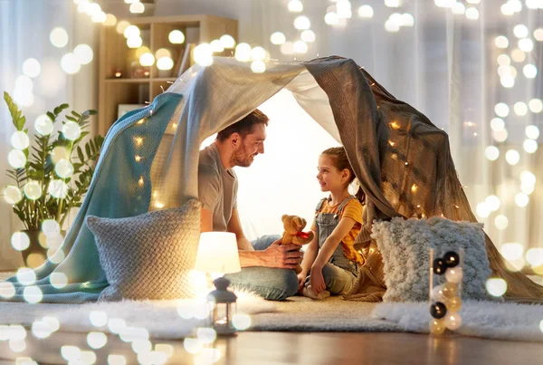 Famiglia felice che gioca con il giocattolo nella tenda dei bambini a casa — Foto Stock