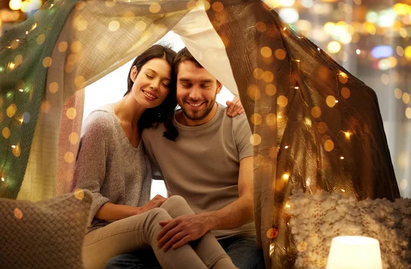 Happy couple in kids tent at home — Stock Photo, Image