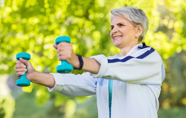 Seniorin mit Kurzhanteln übt im Park — Stockfoto