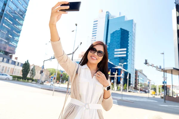 Азиатка делает селфи на смартфоне в городе — стоковое фото