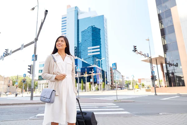 Šťastná mladá asijská žena s cestovním pytlem ve městě — Stock fotografie